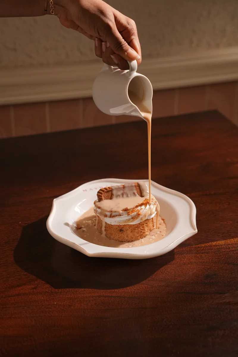 Toffee sauce poured over sticky toffee pudding